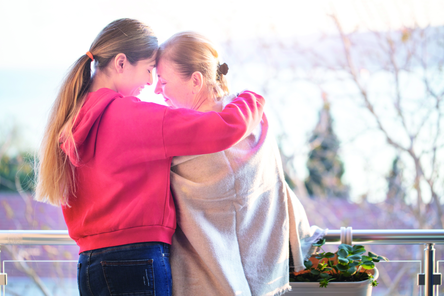 Young worried girl in casual clothes hugging her grandmother